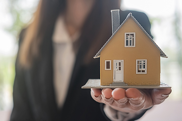 Realtor holding a small model house