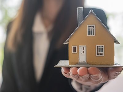 Realtor holding a small model house